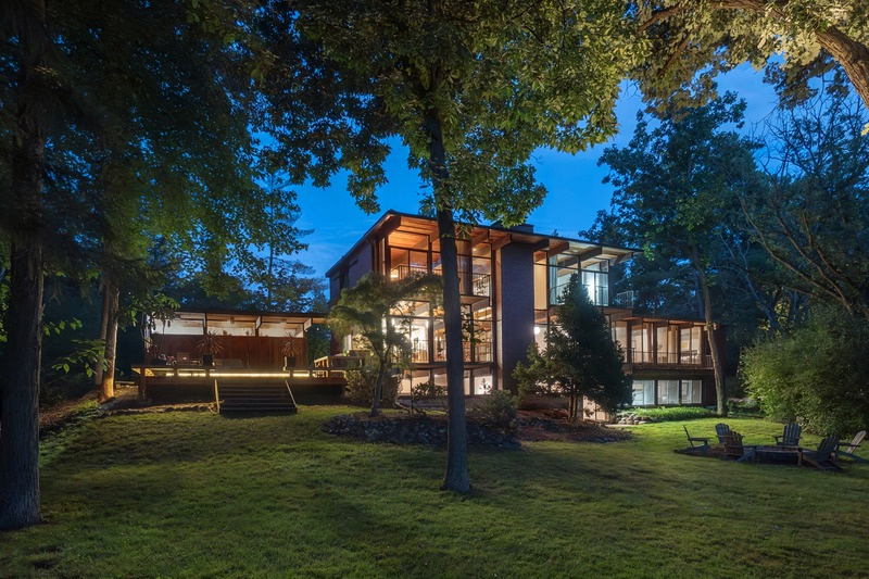 1390 Ridge Road at dusk, glowing through mature oaks and pines